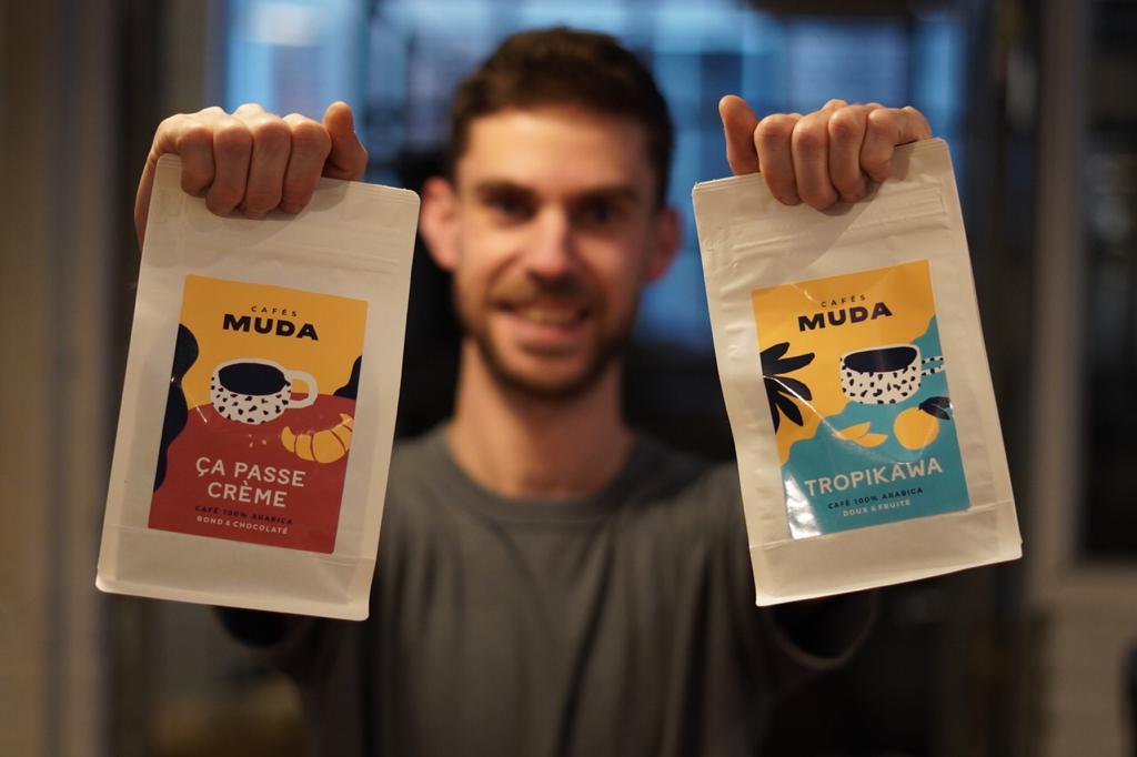 Membre présentant fièrement ses premiers paquets de café